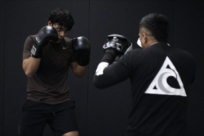 Coach Cris holding pads for a student during private striking training